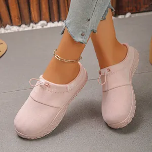 Close-up detail of stylish pink suede slip-on shoes featuring toggle drawstring closure