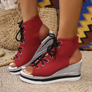 Detailed view of red canvas lace-up wedge sandals featuring a silver woven platform heel