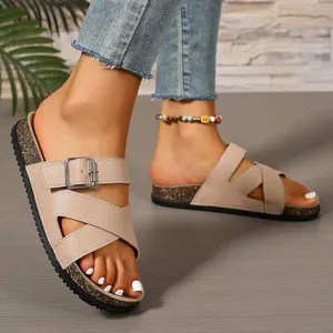 Close-up detail of beige cork sandals with buckle and cross-strap design for women
