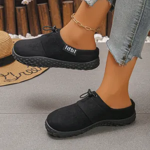 Stylish black suede mules featuring a decorative front tie and durable rubber sole