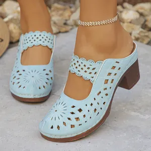 Detailed view of light blue hollow-out heeled mules with elegant laser-cut patterns.