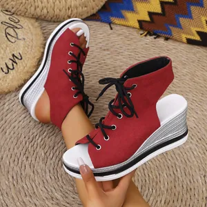 Detailed view of red lace-up wedge sandals with a textured platform sole