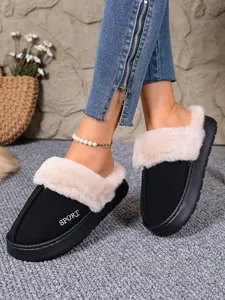 Close-up of black winter slippers featuring plush faux fur trim and SPORT embroidery