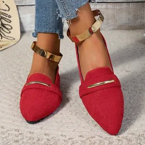 Detailed view of women's red suede pointed flats with decorative gold metal anklet straps.