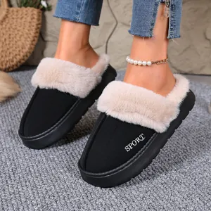 Close-up of black winter slippers with beige fur trim and SPORT print on model's feet