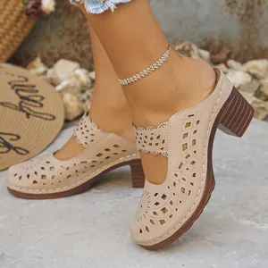 Close-up of beige hollow-out block heel mules with intricate laser-cut floral patterns
