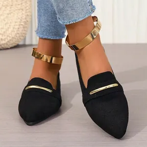 Elegant black pointed-toe flat loafers featuring a stylish polished gold ankle strap.