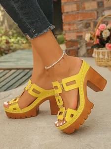 Détail de vue latérale de mules à plateforme jaune avec des talons épais en bois texturé.