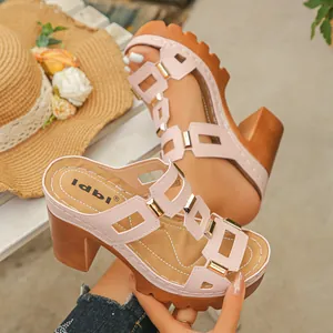Gros plan de sandales compensées roses avec boucles métalliques et talons compensés épais