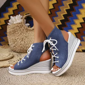 Detailed view of women's blue denim lace-up wedge sandals with silver textured platform heel