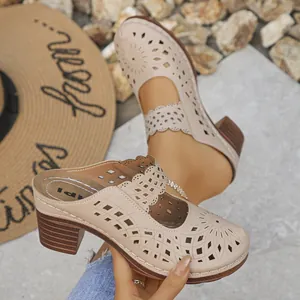 Close-up of beige laser-cut mules with stylish block heel and elegant floral pattern