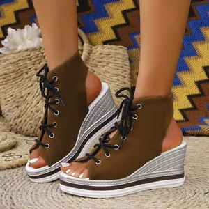 Close-up of olive green suede wedge sandals with lace-up front and silver platform