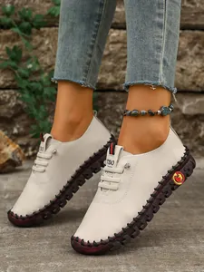 Detalle de zapatos planos blancos casuales cosidos a mano para mujer con suela de goma duradera