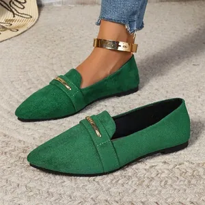 Close-up detail of stylish green suede pointed-toe flat loafers featuring gold metal buckle.