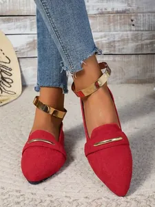 Close-up of red suede pointed-toe flats featuring a chic gold metallic ankle strap