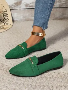 Close-up of green suede pointed-toe flats with gold metal bar decoration
