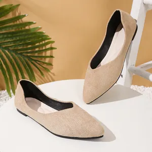 Detailed view of beige pointed-toe flat shoes on a minimalist white table
