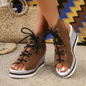 Detail of brown peep-toe wedge sandals with black laces and silver woven platform sole.