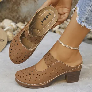Detailed view of brown laser-cut mule clogs with a chunky wood-grain high heel.