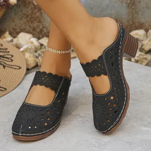 Detail view of stylish black hollow-out floral pattern on elegant closed-toe heeled mules