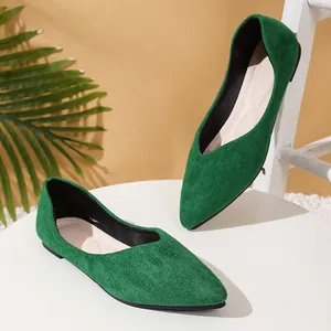 Close-up of green suede pointed-toe flats with soft texture and stylish V-cut design