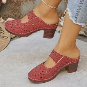 Detailed shot of stylish red laser-cutout closed-toe mules with chunky heels worn by a model