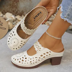 Detailed view of beige hollow-out chunky heel mule sandals with laser-cut patterns.