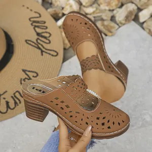 Close-up view of brown hollow-out mules featuring chunky heels and elegant laser-cut patterns.