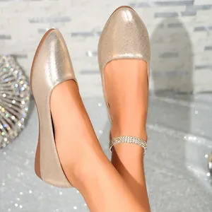 Detailed close-up view of elegant champagne gold shimmer wedge flats with a stylish almond toe