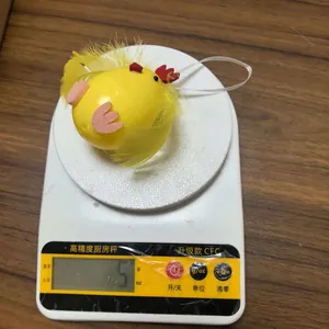 Detalle que muestra el pollito de Pascua con plumas ligero de 5g en una báscula