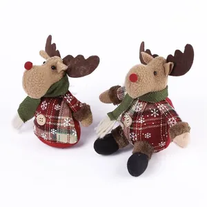 Detail view of two Christmas reindeer plush dolls with red plaid and snowflake patterns.