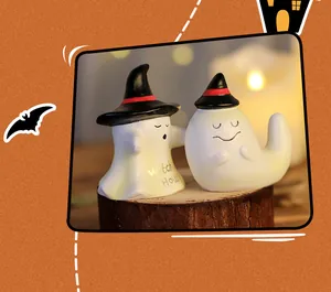 Detailed close-up of two cute Halloween resin ghost figurines wearing black witch hats