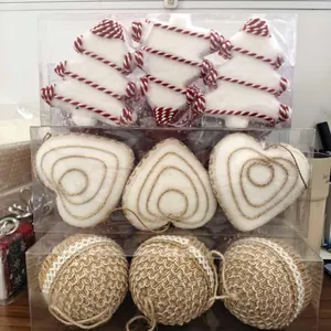 Dettaglio di addobbi natalizi con alberi di schiuma, cuori e palline di juta intrecciata.