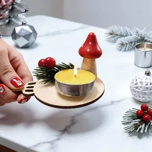 Hand holding a festive wooden mushroom candle holder with berries and pine needles