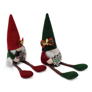 Detailed view of two Christmas gnomes dolls with gingerbread and tree decorations.