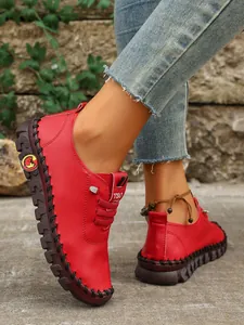 Vista detallada de zapatos planos rojos para mujer con costuras manuales de contraste