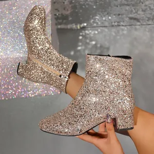 Detailed view of sparkling gold sequined ankle boots with a stylish chunky block heel.
