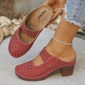 Side view of red hollowed-out chunky heel clogs featuring intricate floral pattern design