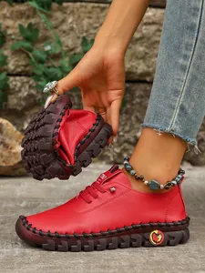 Vista detallada de zapatos casuales de cuero rojo flexible con suela blanda y costuras