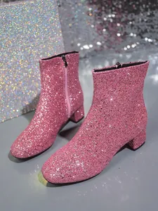 Close-up of pink sequin fashion ankle boots with block heels and side zipper