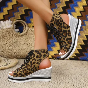 Detailed view of leopard print lace-up wedge sandals with a metallic silver sole
