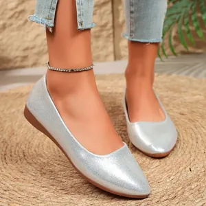 Detail view of silver pointed-toe flat shoes with a metallic finish and casual style.
