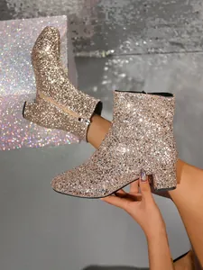 Close-up detail of shimmering rose gold sequin fashion boots with side zipper