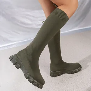 Primer plano de botas calcetín altas de tejido fly-knit verde oliva con suela track