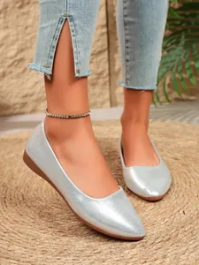 Detailed view of stylish silver pointed-toe flats with shimmering metallic finish