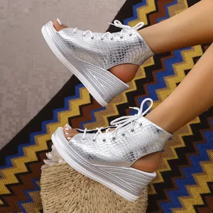 Close-up of silver crocodile texture lace-up peep-toe wedge sandals on a patterned rug