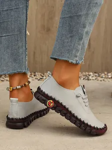 Detalle de zapatos planos grises cosidos a mano con suela gruesa y antideslizante