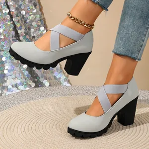 Detail view of light grey chunky heel pumps with elastic cross straps and platform soles.