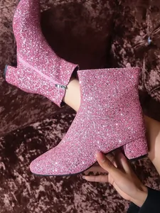 Detail view of pink glitter sequin ankle boots with a stylish block heel design.