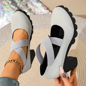 Close-up detail of grey Mary Jane shoes with thick block heels and elastic straps